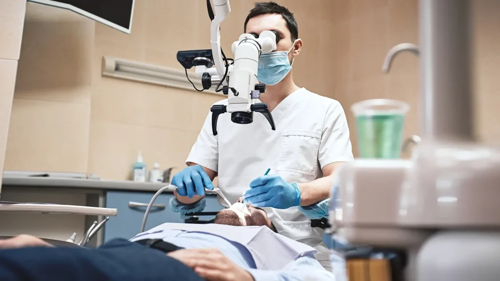 Dentist examining a patient with a dental microscope in Toronto